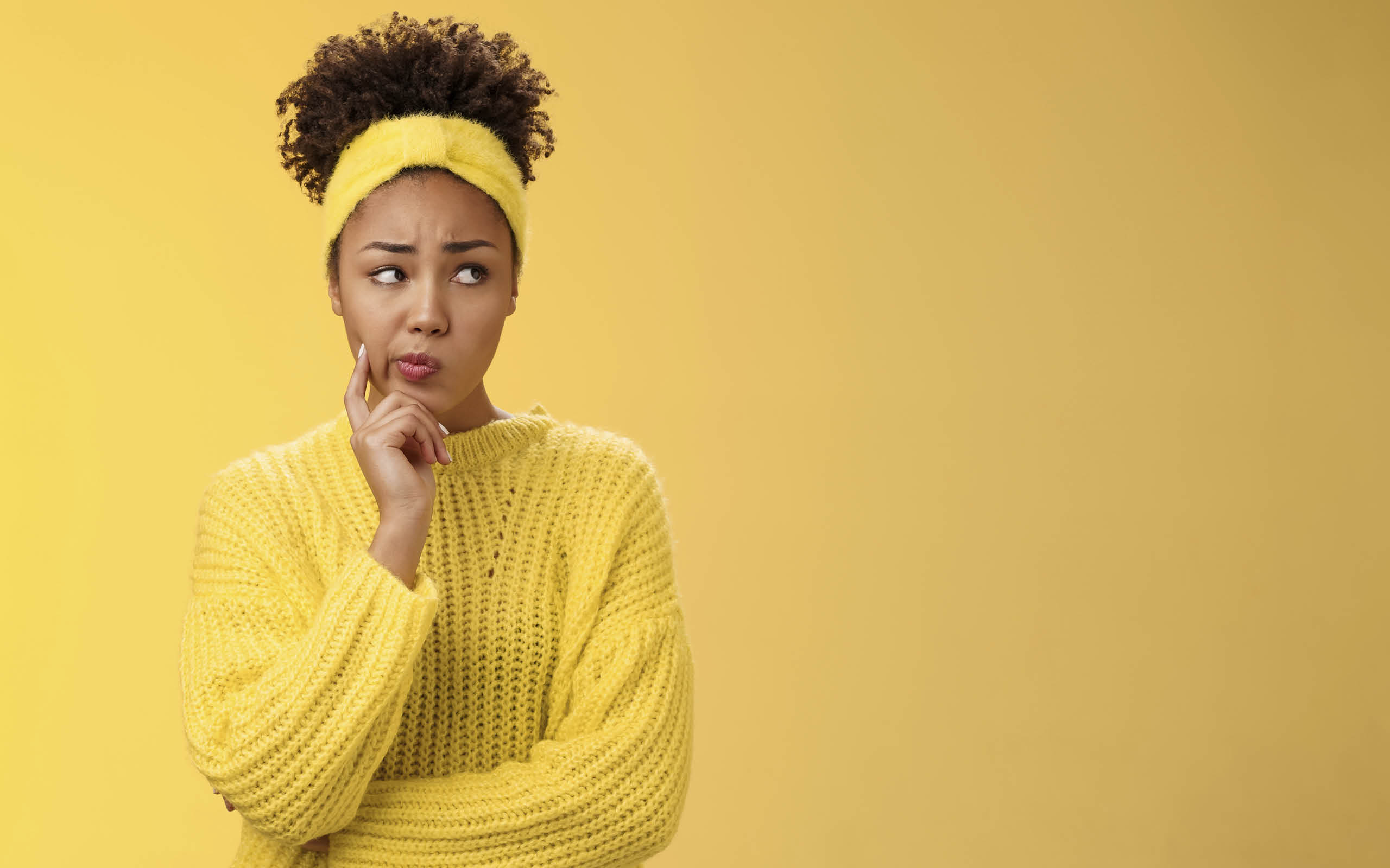 Perplexed unsure cute timid african-american female thinking how escape awkward situation smirking frowning concerned touch cheek thoughtful thinking nervously, worried yellow background.